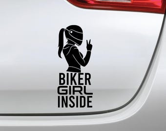 May include: Black vinyl decal featuring a silhouette of a biker wearing a helmet and making a peace sign. The text "BIKER GIRL INSIDE" is below the image, perfect for car windows or other smooth surfaces.