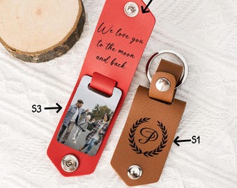 May include: Two leather keychains with a photo insert and a monogram. The red keychain has the text "We love you to the moon and back." The brown keychain has a monogram "P" inside a wreath.