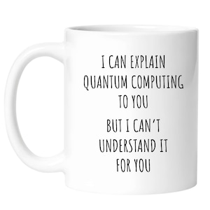 May include: A white ceramic mug featuring black text that reads: I CAN EXPLAIN QUANTUM COMPUTING TO YOU BUT I CAN'T UNDERSTAND IT FOR YOU. The mug has a smooth finish, a curved handle on the left side, and a cylindrical body with a flat base.