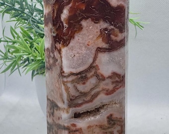 May include: A large, white and red agate crystal point with a natural, polished finish. The crystal has a unique, swirling pattern of red and white.