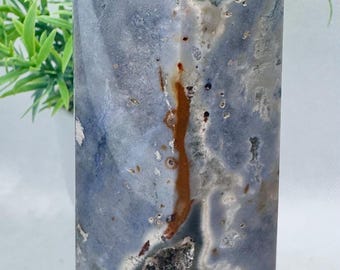 May include: A blue, green, and brown agate crystal point with a hexagonal base. The crystal has a unique pattern of swirls and inclusions.