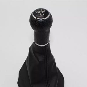 May include: Black leather gear shift knob with a chrome top and a 5-speed pattern. The knob has a textured surface.