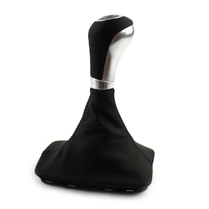 Op de afbeelding: Zwarte leren versnellingspookhoes met een zilveren en zwarte versnellingspookknop.