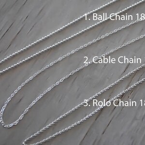 K&ouml;nnte beinhalten: Drei silberne Ketten, jede 45,7 cm lang, liegen auf einer Holzoberfl&auml;che. Die Ketten sind mit "1. Ball Chain 18", "2. Cable Chain 18" und "3. Rolo Chain 18" beschriftet.