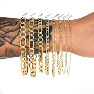 May include: Nine gold chains of different widths, ranging from 2mm to 9mm, are displayed on a person's arm. The chains are all made of gold and have a classic, simple design.