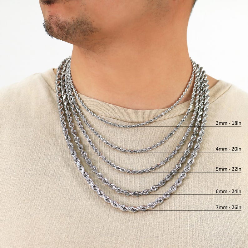 May include: A close-up of a man's neck wearing five different silver rope chains in various lengths. The chains are labelled with their thickness and length in inches: 3mm - 18in, 4mm - 20in, 5mm - 22in, 6mm - 24in, and 7mm - 26in.