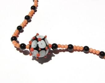 Glass focal bead with vintage coral and onyx beaded necklace.   31