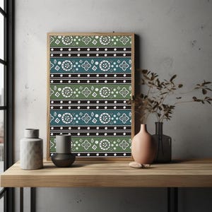 May include: A framed print with a repeating geometric pattern in teal, green, black, and white. The pattern features circular and floral motifs. The frame is made of light brown wood. Decorative vases are on a wooden shelf.