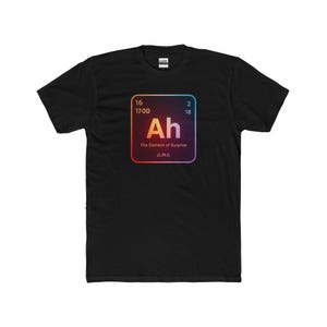 May include: Black t-shirt with a graphic resembling a periodic table element. The graphic displays "Ah" and "The Element of Surprise". The shirt is made of a soft material and has a crew neck. The graphic is in a square shape.