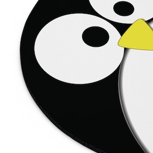 May include: A cartoon penguin design in black and white, featuring large white eyes and a yellow beak. The penguin's body is black, with white details. The design is simple and suitable for various products.
