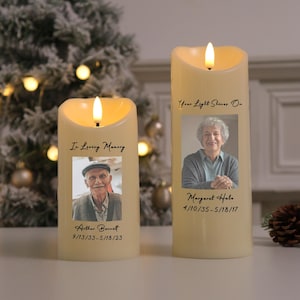 Könnte beinhalten: Zwei elfenbeinfarbene LED-Kerzen mit flackernden Flammen. Jede Kerze zeigt ein Foto und den Text: "In Loving Memory" und "Your Light Shines On." Eine Kerze zeigt "Arthur Bennett 9/13/33-5/18/23" und die andere "Margaret Halo 4/10/35-5/18/17."