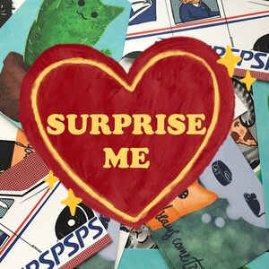 Puede incluir: Un coraz&oacute;n rojo con un contorno amarillo y las palabras "SURPRISE ME" en letras amarillas. El coraz&oacute;n est&aacute; rodeado de tarjetas coloridas con varios dise&ntilde;os, incluyendo gatos, un cactus y un cami&oacute;n de correo.