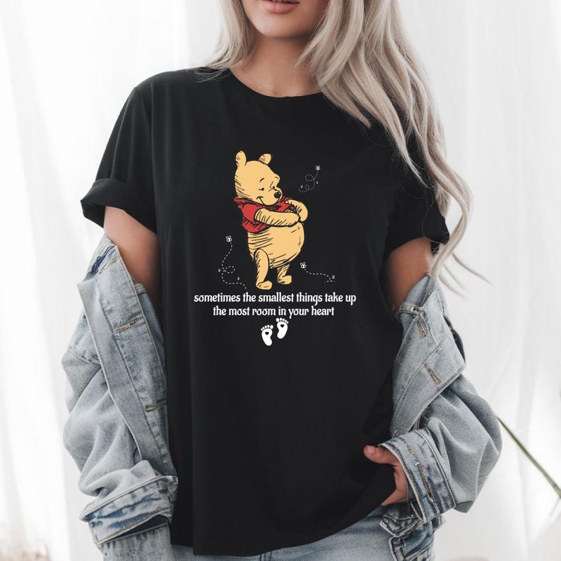 May include: Black t-shirt featuring a cartoon image of Winnie the Pooh with the text "sometimes the smallest things take up the most room in your heart".