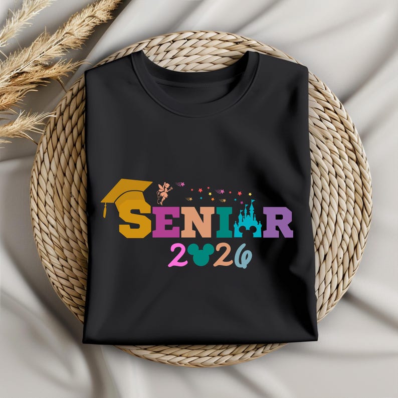 May include: Black t-shirt with the word "SENIOR" in colorful letters, a graduation cap, and the year "2020". The design includes a castle and Mickey Mouse ears.
