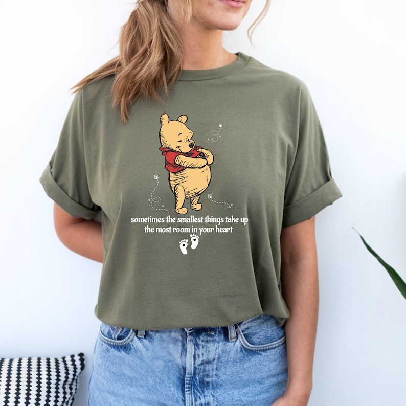 May include: A green t-shirt with a cartoon image of Winnie the Pooh and the text "sometimes the smallest things take up the most room in your heart".