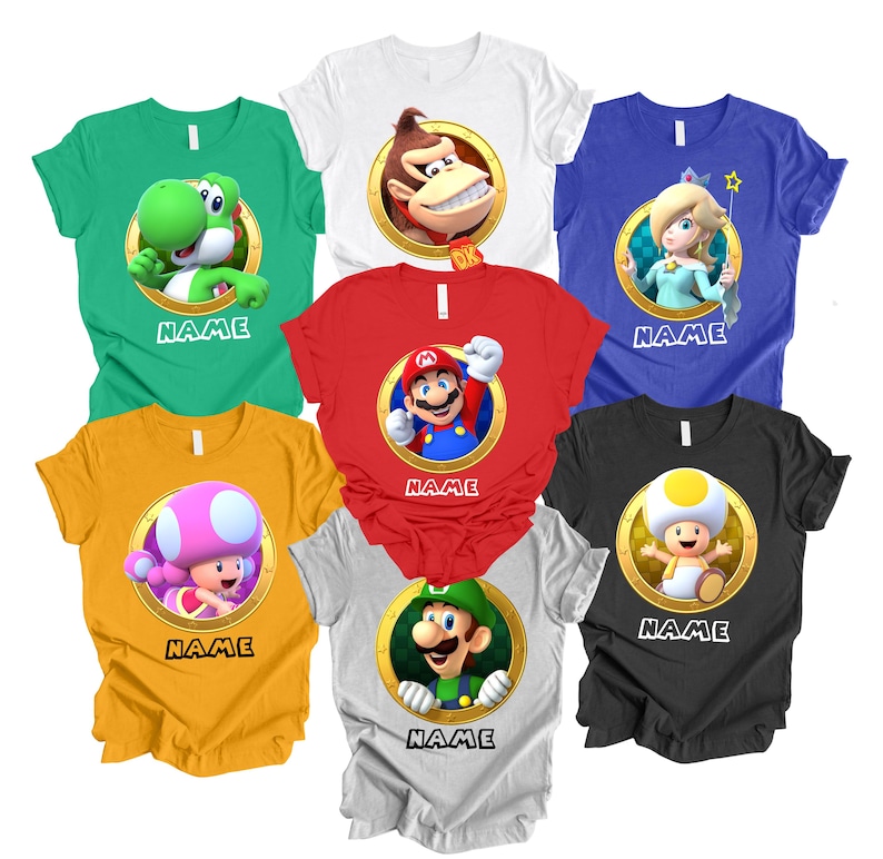 Peut inclure: Plusieurs t-shirts color&eacute;s avec des personnages d'une c&eacute;l&egrave;bre s&eacute;rie de jeux vid&eacute;o. Chaque chemise pr&eacute;sente un personnage dans un cadre circulaire dor&eacute;, avec le mot "NAME" imprim&eacute; en dessous. Les chemises sont de diff&eacute;rentes couleurs, dont vert, blanc, rouge, bleu, jaune, gris et noir.