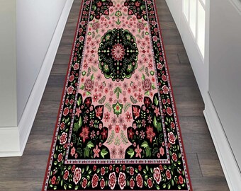 May include: A pink and black patterned rug with a floral design. The rug has a burgundy border and is ideal for adding a touch of elegance to any room.