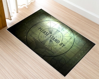 May include: A green and black rug with a vintage television test pattern and the text "PLEASE STAND BY".