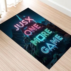 May include: Rectangular rug with a dark blue background and a neon sign that reads "JUSX ONE MORE GAME". The neon text is in pink, blue, and green. The rug has a mountain landscape design.