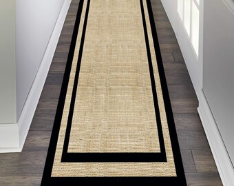 May include: A beige runner rug with a black double border. The rug is made of a woven material and has a subtle texture.