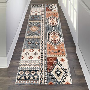May include: A long runner rug with a geometric pattern in shades of brown, orange, and blue. The rug has a traditional, tribal design with intricate details.