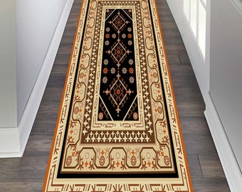 May include: A black and cream runner rug with an intricate geometric pattern in shades of brown, orange, and cream. The rug has a thick orange border.