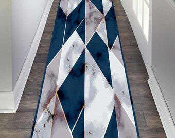 May include: A navy blue runner rug with a geometric design. The rug features white, grey, and marble-like patterns, outlined with gold accents. The rug is rectangular and appears to be in a hallway.