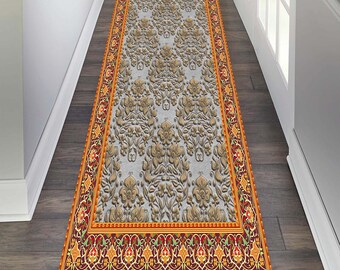 May include: A long runner rug with a detailed floral pattern in shades of gold, red, and orange. The rug has a border with intricate designs and a white background.