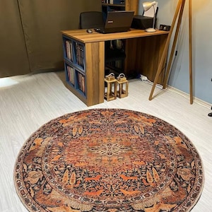 May include: A round, multi-colored rug with a traditional Persian design. The rug features intricate patterns of flowers, leaves, and animals in shades of red, orange, blue, and black.