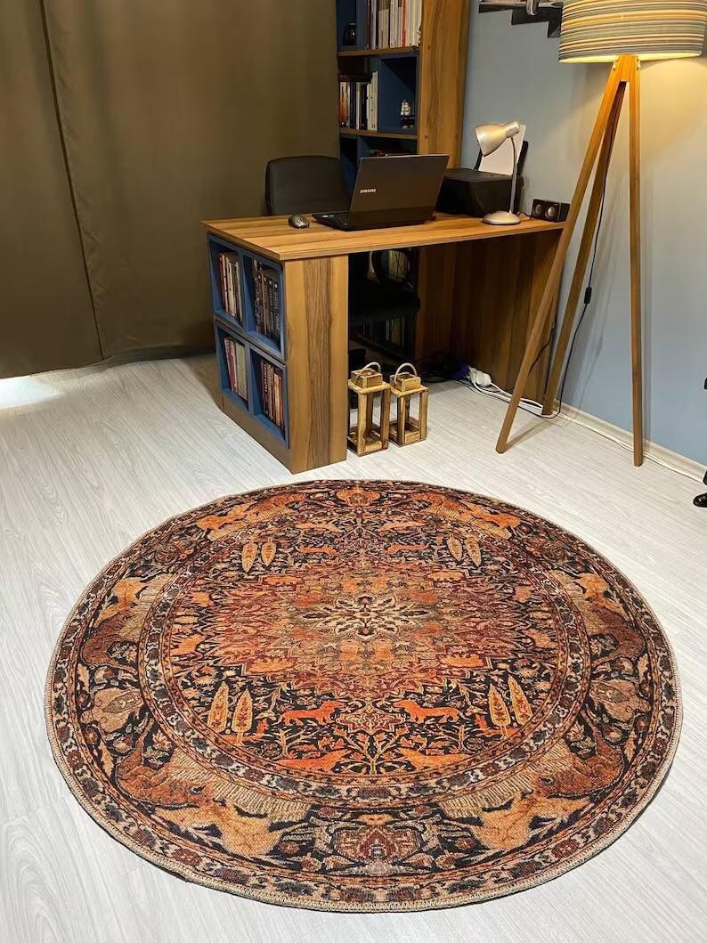 May include: A round, multi-colored rug with a traditional Persian design. The rug features intricate patterns of flowers, leaves, and animals in shades of red, orange, blue, and black.