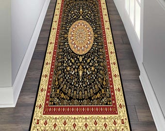 May include: A black and gold patterned runner rug with a red border. The rug features a large, intricate, circular design in the centre.