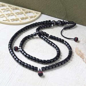 Tasbih de madera negra auténtica de 100 cuentas - Hecho a mano con cuentas cortas en forma de barril de 8 x 9 mm con separadores de hilo en bucle y Alif grabado. Presentado en caja de regalo.