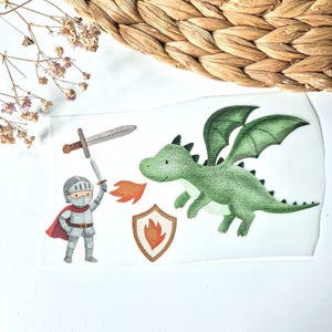 Könnte beinhalten: Eine skurrile Illustration mit einem Ritter in silberner Rüstung mit rotem Umhang, der ein Schwert hochhält. Ein grüner Drache mit ausgebreiteten Flügeln und ein Schild mit Flammendesign sind ebenfalls abgebildet. Das Kunstwerk hat ein Märchen-Thema.