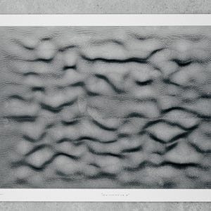 May include: A black and white photograph of a textured surface with a rippled pattern. The image is titled "La memoria #".