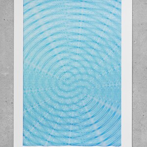 May include: Abstract art print with concentric circles in light blue hues, producing a rippling effect. The artwork is set against a white backdrop, with the word "Interference" printed in the bottom right corner.