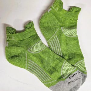 May include: A pair of green ankle socks with gray accents and the word "Peruvian" on the heel.