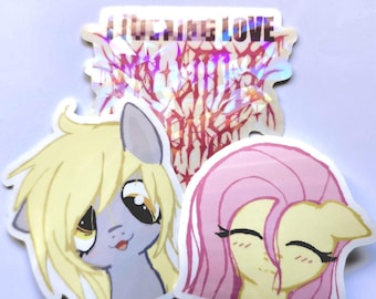 May include: Three die-cut stickers featuring cartoon ponies. One sticker has holographic text that reads I FUCKING LOVE MY LITTLE PONY. Another sticker shows a grey pony with blonde hair, and the third shows a yellow pony with pink hair.