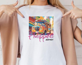 May include: White t-shirt with a colorful illustration of a jeepney, a type of public transportation in the Philippines. The text "Philippines Jeepney" is printed below the image.
