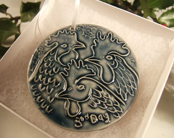 May include: A blue and white ceramic ornament featuring three stylised roosters and the text "3rd Day".