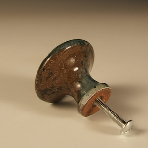May include: A brown and green ceramic cabinet knob with a silver screw.