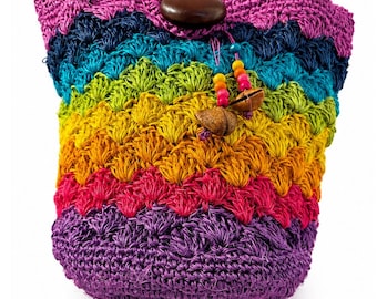 Puede incluir: Un bolso de ganchillo con rayas horizontales en tonos vibrantes de morado, rosa, naranja, amarillo, verde lima, azul verdoso y azul marino. El bolso se cierra con un botón de madera marrón oscuro y tiene cuentas de madera colgantes.