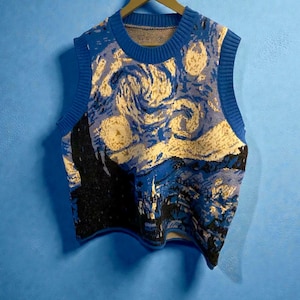 Puede incluir: Un chaleco de punto azul y crema con un diseño inspirado en la pintura "La noche estrellada" de Van Gogh. La parte superior sin mangas tiene cuello redondo y dobladillos acanalados. La obra de arte representa nubes arremolinadas y un pueblo.