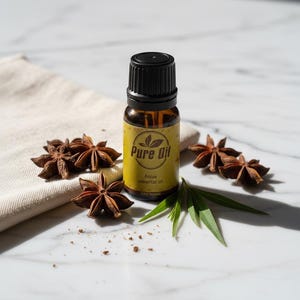 Peut inclure: Une petite bouteille en verre ambré d'huile essentielle d'anis "Pure Oil" avec un bouchon noir, entourée d'anis étoilé et de feuilles vertes. La bouteille porte une étiquette jaune avec du texte et un logo. Les éléments sont disposés sur une surface en marbre blanc.