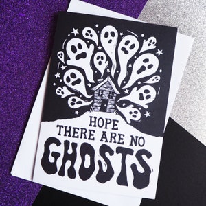 May include: Black and white illustration of a house with ghosts flying around it. The text "Hope there are no ghosts" is written below the house.