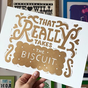 That takes the biscuit linocut print Gold on white