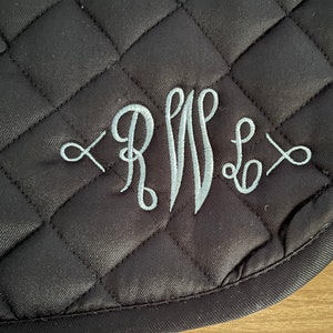 以下が含まれることがあります： 銀色の刺繍で「RWS」のモノグラムが施された、黒いキルティングの鞍パッドです。
