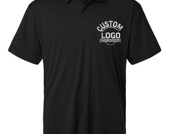 May include: Black polo shirt with short sleeves and a collar. The shirt has white embroidered text reading "CUSTOM LOGO EMBROIDERY" in a curved design on the left chest.