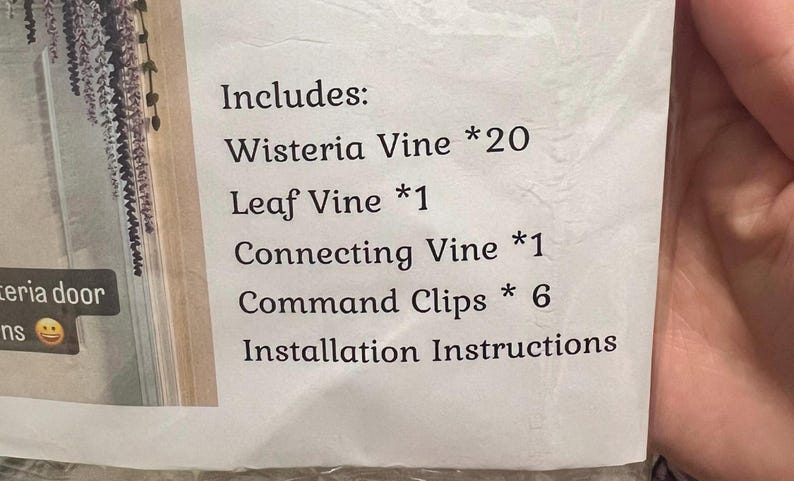 Peut inclure: Une liste imprim&eacute;e des &eacute;l&eacute;ments inclus dans un kit de d&eacute;coration de porte de glycine. La liste comprend 20 vignes de glycine, 1 vigne de feuilles, 1 vigne de connexion, 6 clips de commande et des instructions d'installation.
