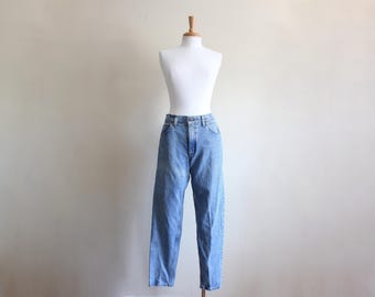 May include: Light blue denim jeans with a relaxed fit. The jeans have a high waist and a straight leg.