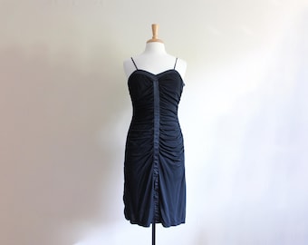 May include: A black, sleeveless dress with a ruched bodice and a fitted silhouette.
